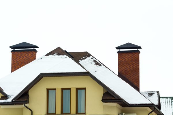 Low angle view of the upper floors of a new large house. Window and roof detail of residential home building. Real estate property.